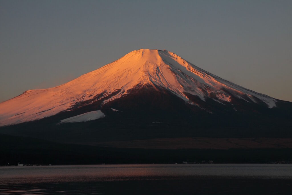 日の出に照らされた富士山の写真